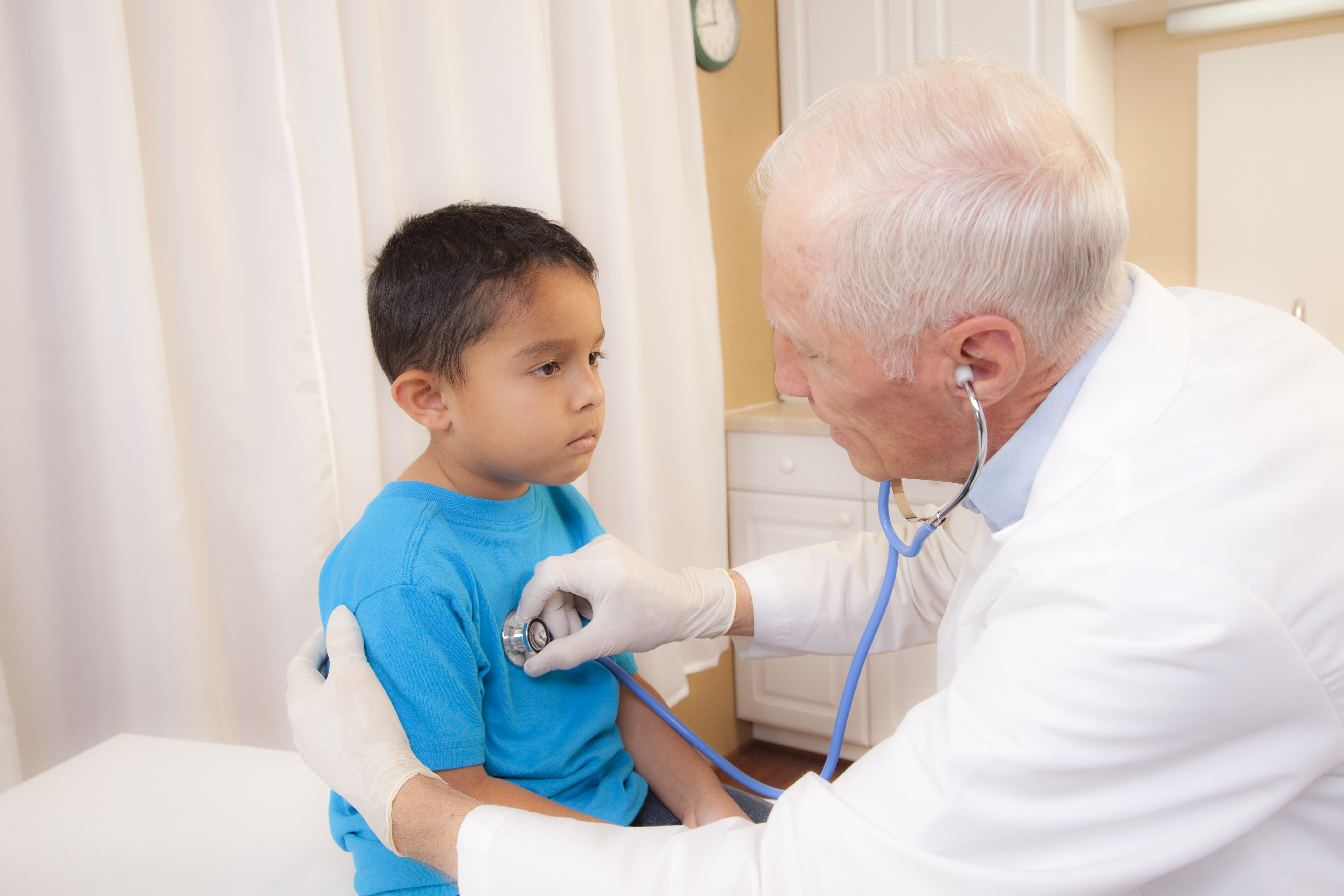Medical: Latin boy in doctor's office on exam table.