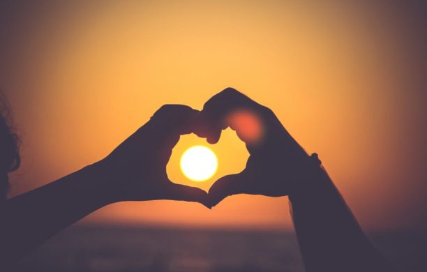 heart hands around sunset